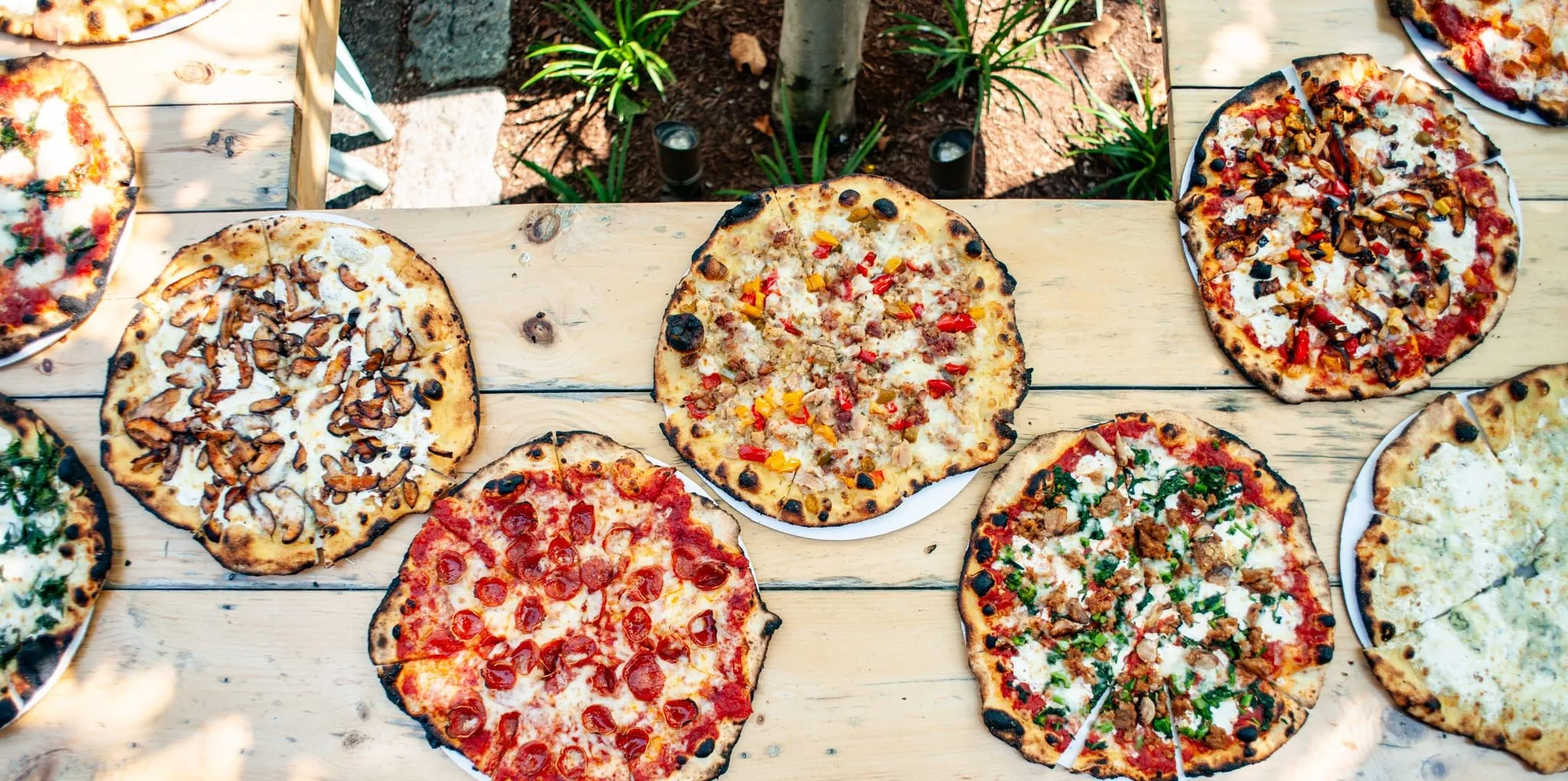 five wood-fired pizza options on table