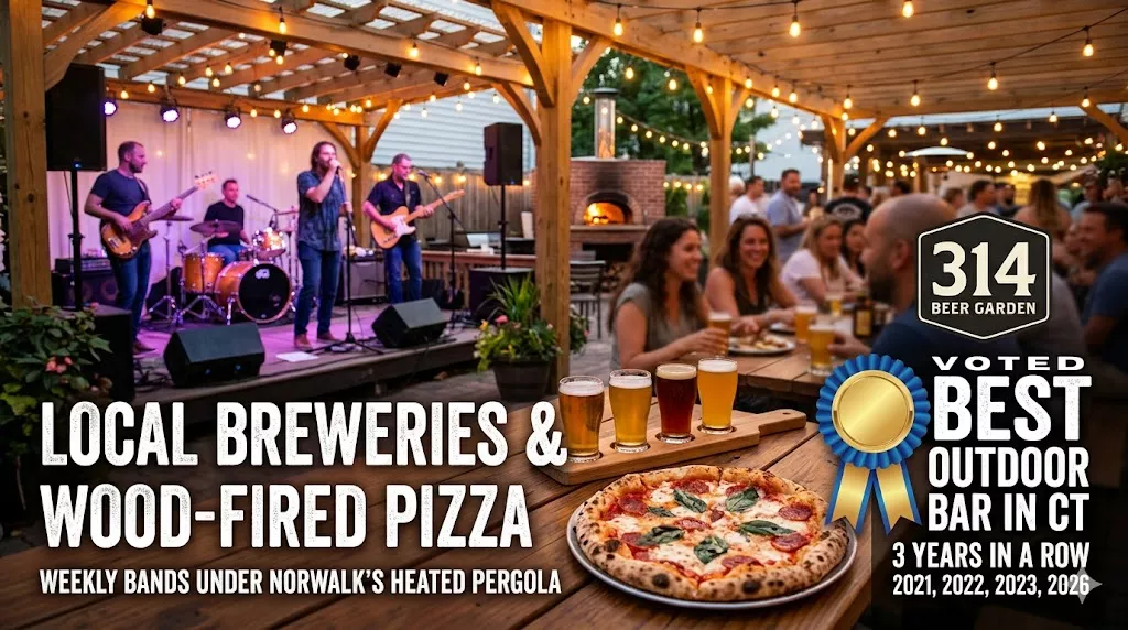 A close-up of a craft beer flight and wood-fired pizza at 314 Beer Garden in Norwalk CT, featuring a blurred live band on stage in the background. Voted Best Outdoor Bar in Connecticut.